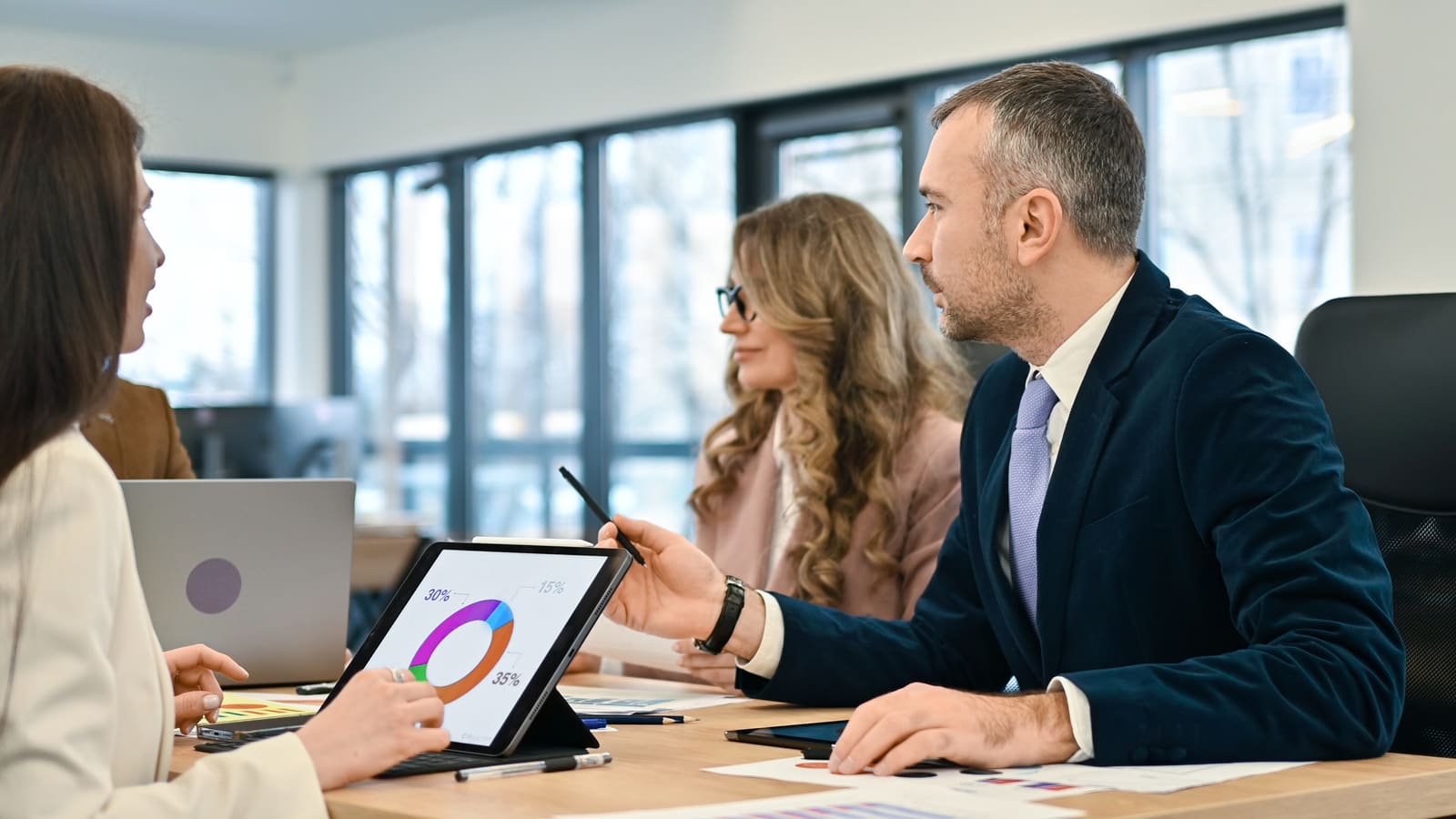Investment team examining a portfolio allocation chart on a tablet